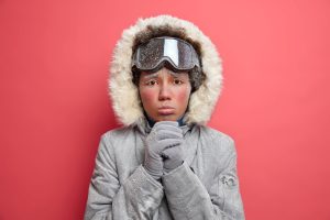 Woman miserable with a cold and jacket on covered in snow