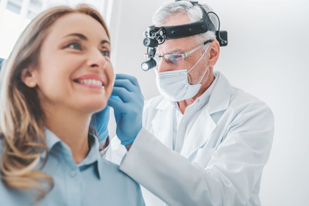 ENT doctor examining patient's ear